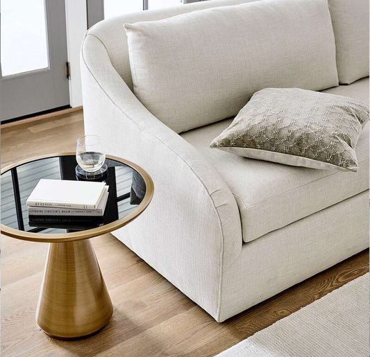 The Addie side table shown here, complementing an off-white upholstered sofa, is shown in our bronze finish with a black glass top insert.