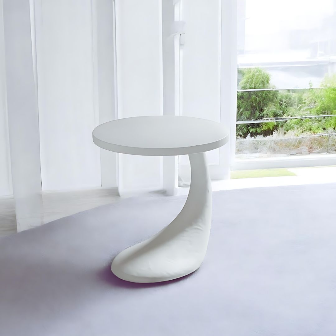 Pictured here in a lifestyle photo, The Cornucopia End Table brings a touch of whimsy and artistic flair to any sitting room with its playful form and distinct plaster texture.
This funky and unique table is more than just a functional piece—it's a true conversational centerpiece that captures attention and sparks curiosity. The Cornucopia features a one-of-a-kind sculptural base that defies convention, making it the perfect choice for those who appreciate bold, avant-garde design.