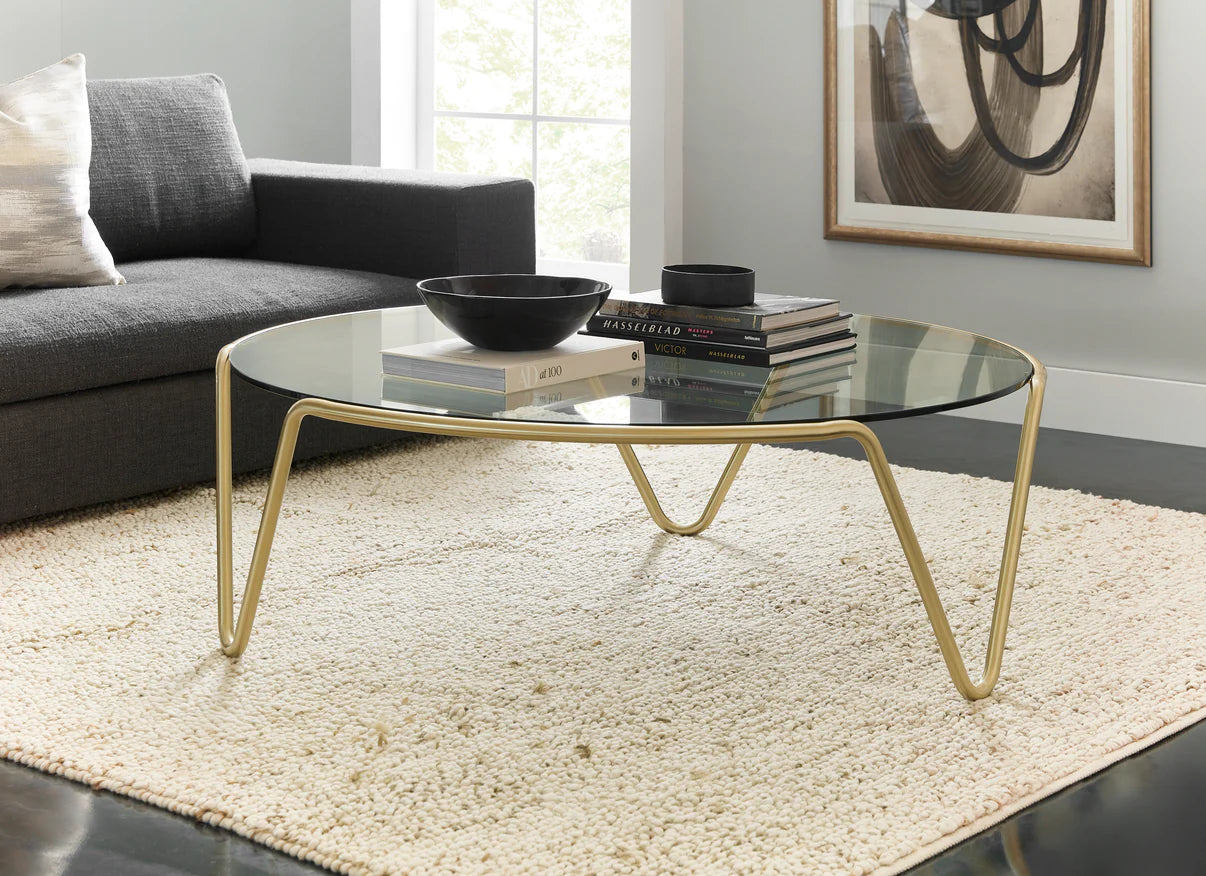 Pictured in this lifestyle photo, The Ripple Cocktail Table is a modern masterpiece that brings an artistic touch to any living room or lounge area.
Featuring a round glass top and a sleek metal frame, this contemporary cocktail table offers a sophisticated and airy look that complements a variety of decor styles. The table's subtle yet refined base design creates a sense of fluidity and elegance, making it a unique statement piece for modern interiors.