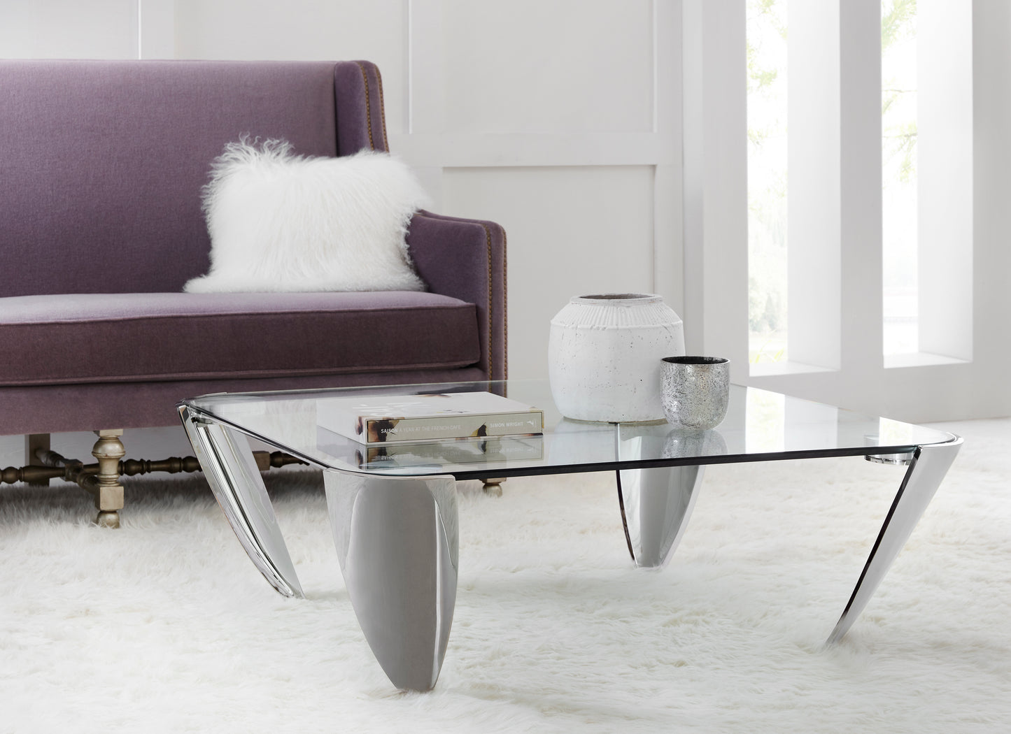 This Modern Elements cocktail table, The Arro, features a tempered glass top and a metal frame.