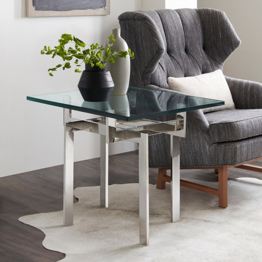 Pictured here is the Zig Zag Accent table by Modern Elements Furniture. With its sleek stainless steel frame and square glass tabletop, this modern accent table features an intricate base that creates a captivating optical illusion, where the legs appear to twist and intersect in a geometric dance. The unique sculptural design adds a sophisticated touch to your decor, making it perfect for displaying decor, holding lamps, or serving as a stylish side table.