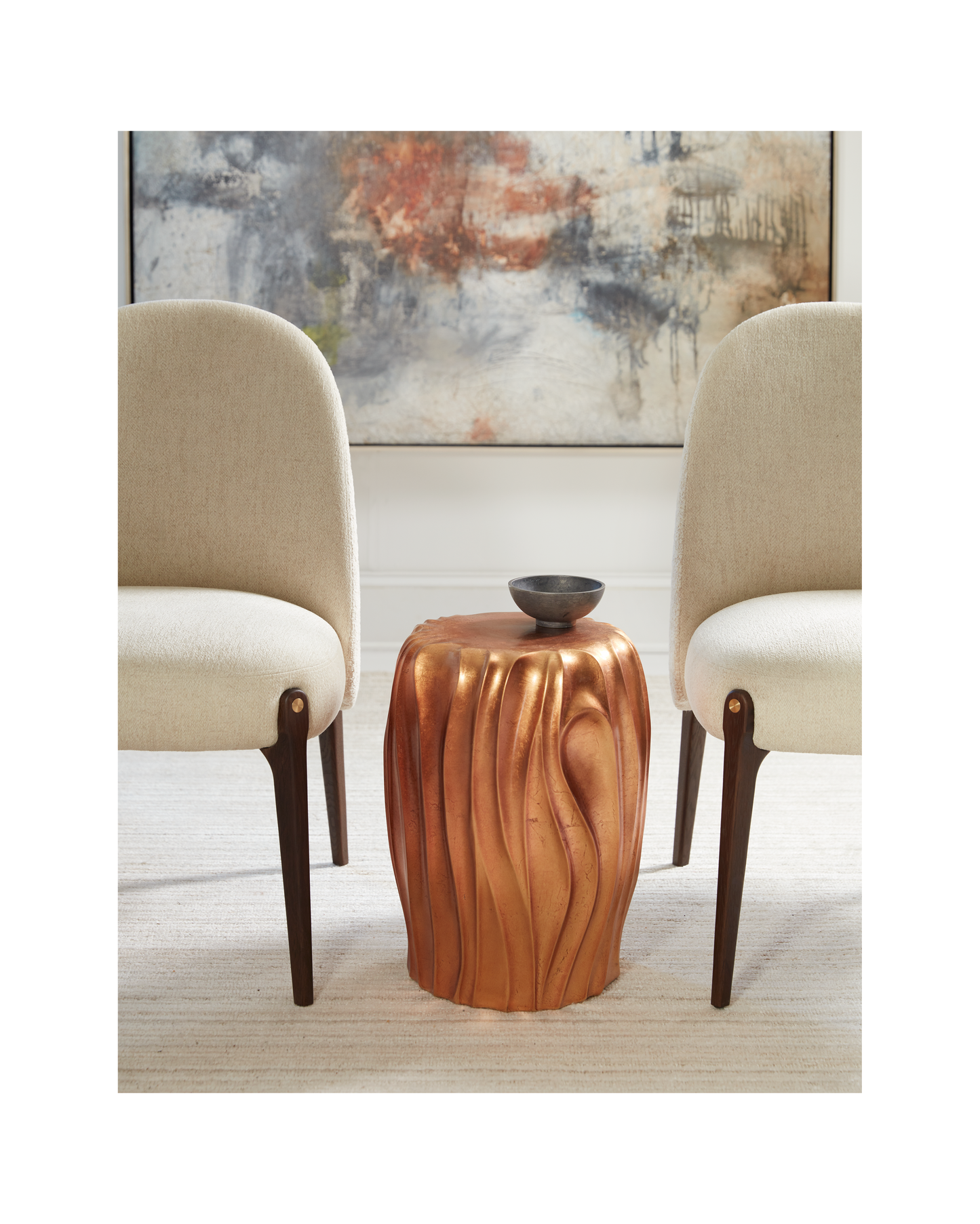 Pictured in this lifestyle photo, The Orabella Pull-Up Table is a captivating resin accent piece that brings a touch of organic elegance to any room.

Made in America, this sculptural table showcases a beautiful free-flowing shape that adds movement and warmth to your space. The table is finished in a luxurious hand-applied distressed gold leaf, creating a vibrant and eye-catching focal point.