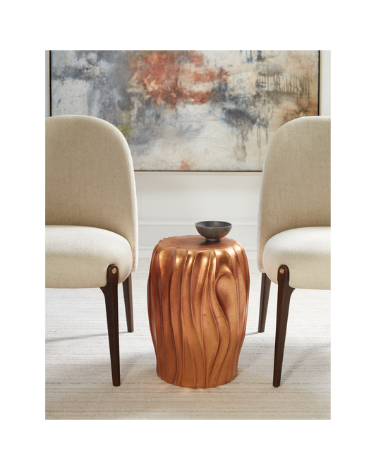 Pictured in this lifestyle photo, The Orabella Pull-Up Table is a captivating resin accent piece that brings a touch of organic elegance to any room.

Made in America, this sculptural table showcases a beautiful free-flowing shape that adds movement and warmth to your space. The table is finished in a luxurious hand-applied distressed gold leaf, creating a vibrant and eye-catching focal point.