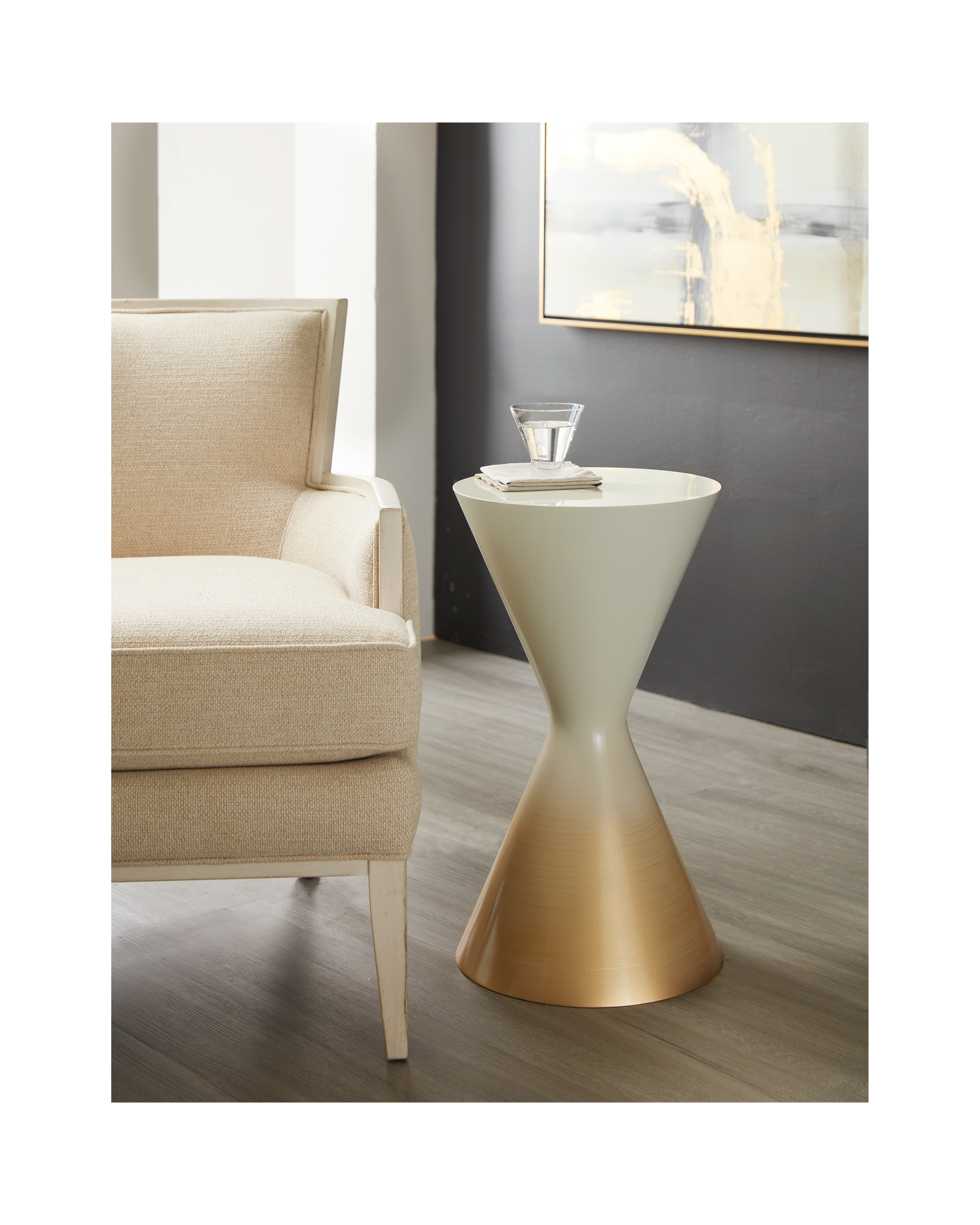 Pictured here in this lifestyle shot, The Sablier Pull-Up Table is a stunning blend of simplicity and elegance, perfect for adding a modern touch to any living space.

This handcrafted resin table is made in the USA and features a unique hourglass shape that creates a sculptural presence in any room. Its gradient Gold to White finish adds a sophisticated flair, transforming a simple design into a true statement piece. 