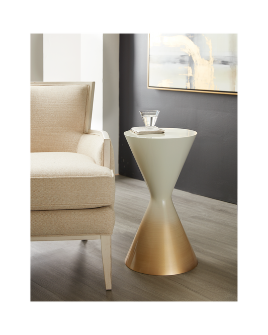 Pictured here in this lifestyle shot, The Sablier Pull-Up Table is a stunning blend of simplicity and elegance, perfect for adding a modern touch to any living space.

This handcrafted resin table is made in the USA and features a unique hourglass shape that creates a sculptural presence in any room. Its gradient Gold to White finish adds a sophisticated flair, transforming a simple design into a true statement piece. 