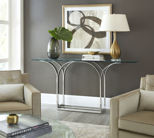 Pictured here in this lifestyle shot, The Trellis Console Table is a sleek and sophisticated addition to any lounge area or living room. Featuring a sturdy stainless steel base and a clear glass tabletop, this console table embodies a modern aesthetic with its clean lines and minimalist form.

Inspired by the intricate geometric patterns of a classic trellis design, the table’s base showcases an elegant interplay of lines and angles, creating a visually striking effect.